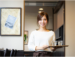 女性がコップを運んでいるシーンの画像